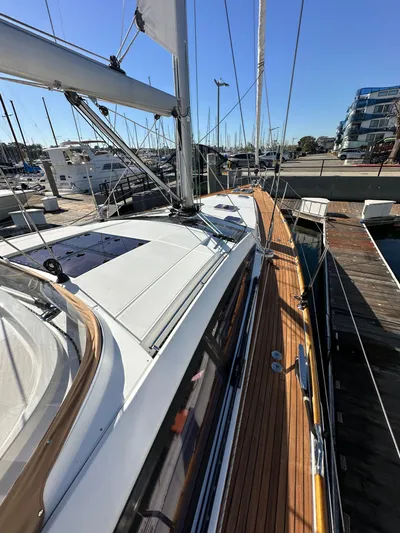 Dharma Yacht Photos Pics 2013 Jeanneau 57 yacht docked at marina, showcasing sleek deck design.