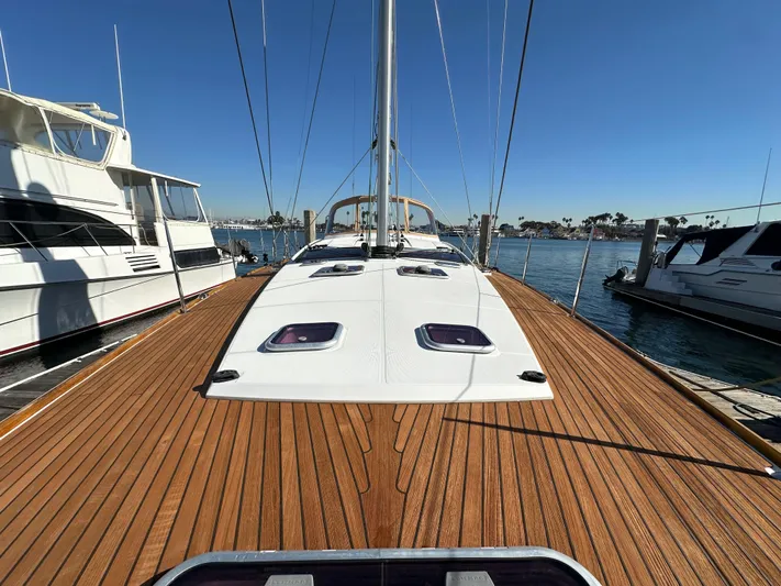 Dharma Yacht Photos Pics 2013 Jeanneau 57 sailboat with teak deck, docked in a marina.