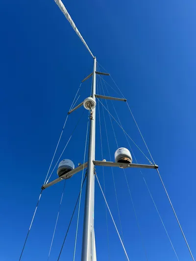 Dharma Yacht Photos Pics Mast of 2013 Jeanneau 57 sailboat against clear blue sky.