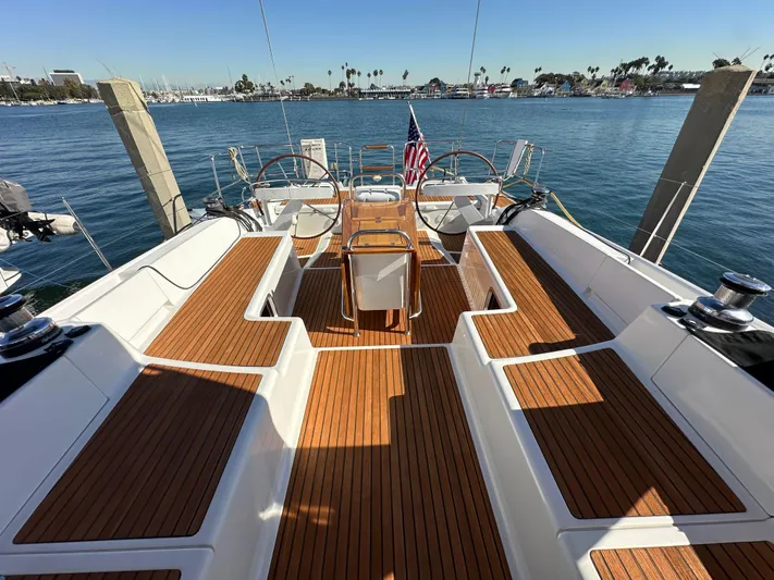 Dharma Yacht Photos Pics 2013 Jeanneau 57 yacht with teak deck, docked in a marina.