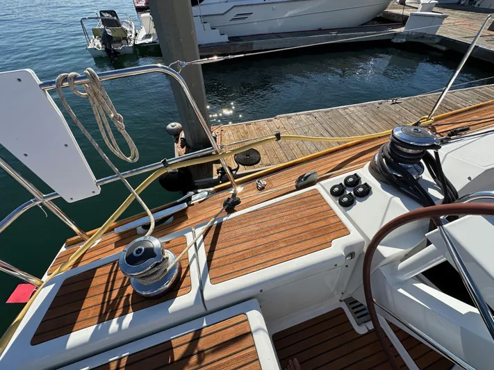 Dharma Yacht Photos Pics Jeanneau 57 sailboat deck, 2013 model, with wooden finish and winches at marina.