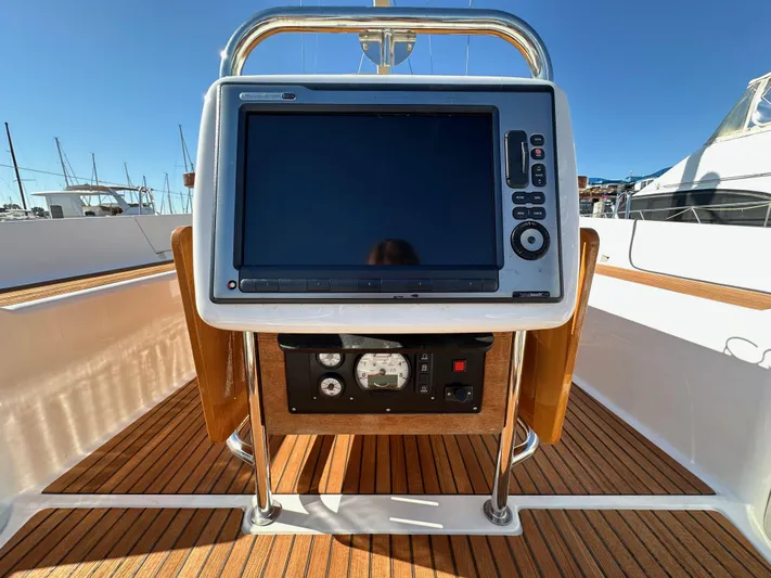 Dharma Yacht Photos Pics Jeanneau 57 yacht helm with navigation display, 2013 model, teak deck, marina background.