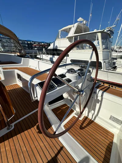 Dharma Yacht Photos Pics 2013 Jeanneau 57 yacht helm with wooden deck, docked in marina.