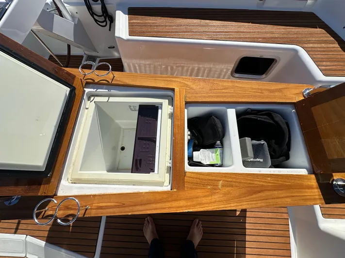 Dharma Yacht Photos Pics Jeanneau 57 yacht cockpit storage compartments, 2013 model, with wooden finish and open lids.