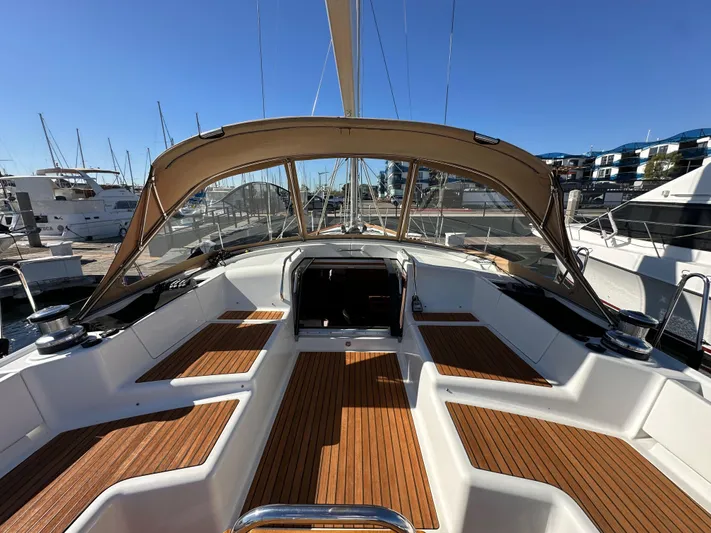 Dharma Yacht Photos Pics 2013 Jeanneau 57 sailboat cockpit with teak flooring and canopy in marina.