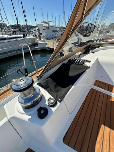 Dharma Yacht Photos Pics 2013 Jeanneau 57 yacht deck with winch and wooden flooring at marina.