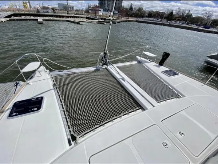 Blue Mind Yacht Photos Pics 2018 Lagoon 380 S2 catamaran deck with netting, docked at a marina.