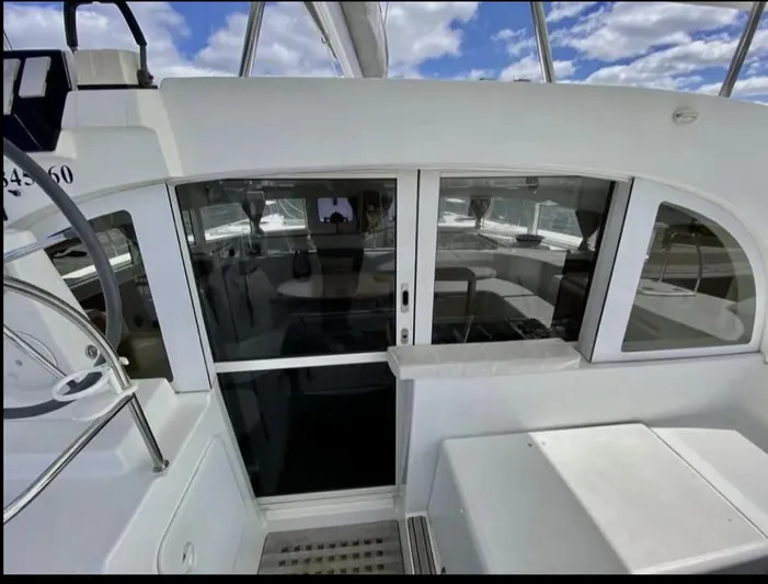 Blue Mind Yacht Photos Pics Lagoon 380 S2 yacht cockpit with sliding doors, 2018 model, under a partly cloudy sky.