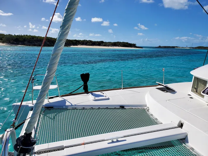 Blue Mind Yacht Photos Pics Lagoon 380 S2 catamaran sailing in clear turquoise waters near a tropical island, 2018 model.