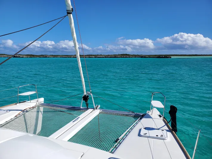 Blue Mind Yacht Photos Pics Lagoon 380 S2 catamaran sailing on turquoise waters under a clear blue sky, 2018 model.