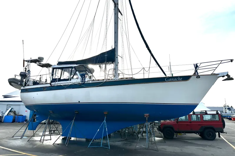 Ganache II Yacht Photos Pics Sailboat "Ganache" on stands, Liberty 458 model, 1985, with a red vehicle nearby.