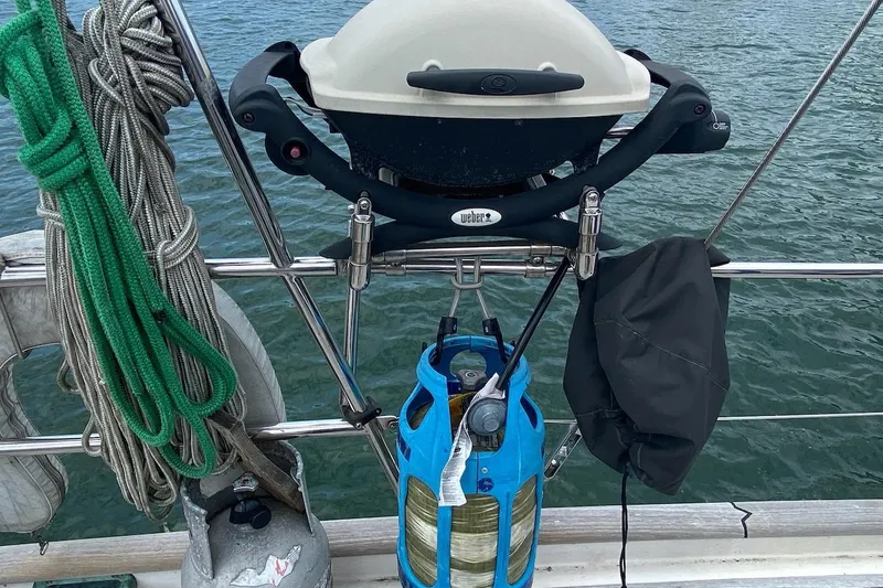 Ganache II Yacht Photos Pics Outdoor grill setup on Liberty 458 sailboat, 1985 model, with ropes and propane tank.