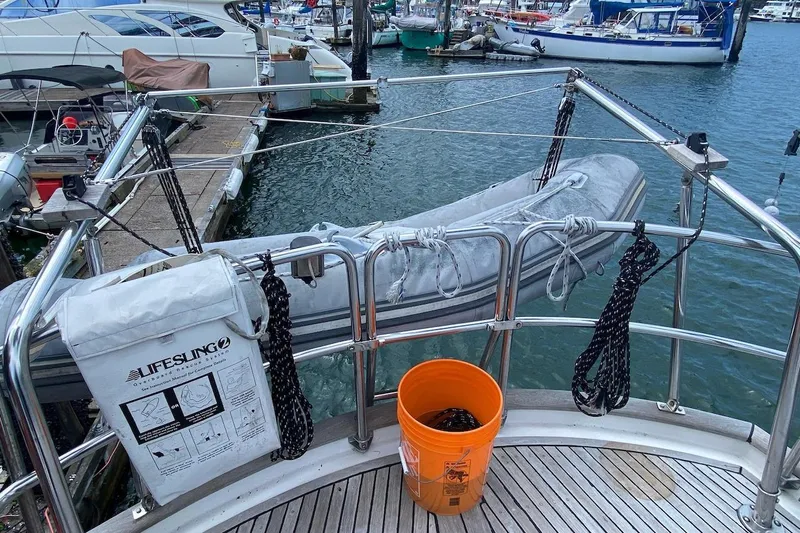Ganache II Yacht Photos Pics Boat deck with Lifesling, orange bucket, and docked inflatable boat, Liberty 458, 1985.