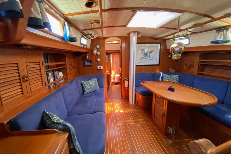 Ganache II Yacht Photos Pics Luxurious 1985 Liberty 458 yacht interior with blue seating, wooden finishes, and nautical decor.