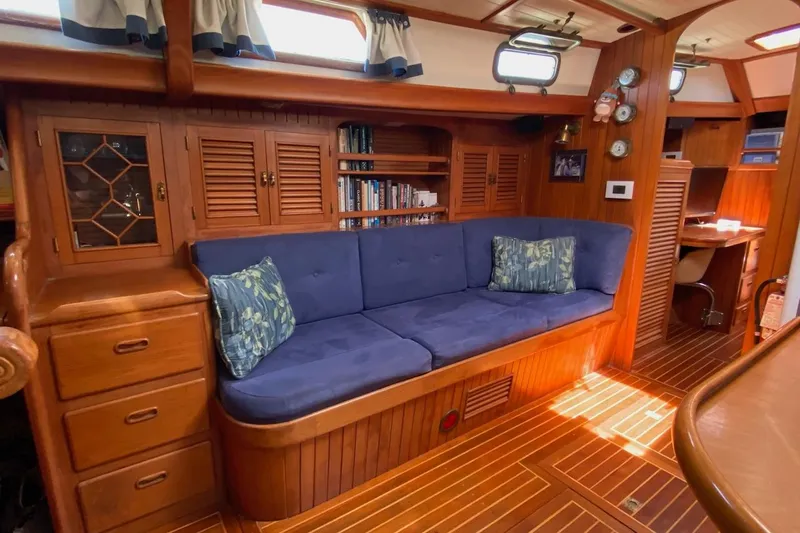 Ganache II Yacht Photos Pics Cozy 1985 Liberty 458 yacht interior with blue sofa, wooden cabinets, and nautical decor.