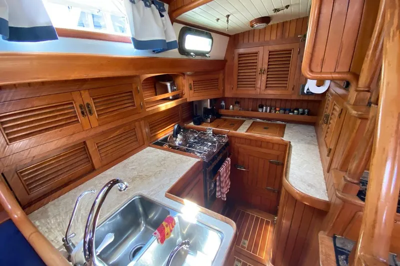 Ganache II Yacht Photos Pics Vintage 1985 Liberty 458 yacht kitchen with wooden cabinetry and modern amenities.