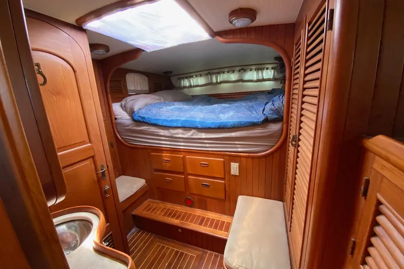 Ganache II Yacht Photos Pics Cozy wooden cabin interior of 1985 Liberty 458 yacht with bed and storage.