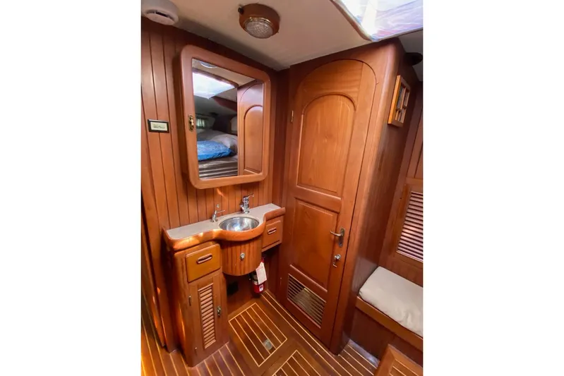 Ganache II Yacht Photos Pics Luxurious wooden interior of 1985 Liberty 458 yacht bathroom with sink and mirror.