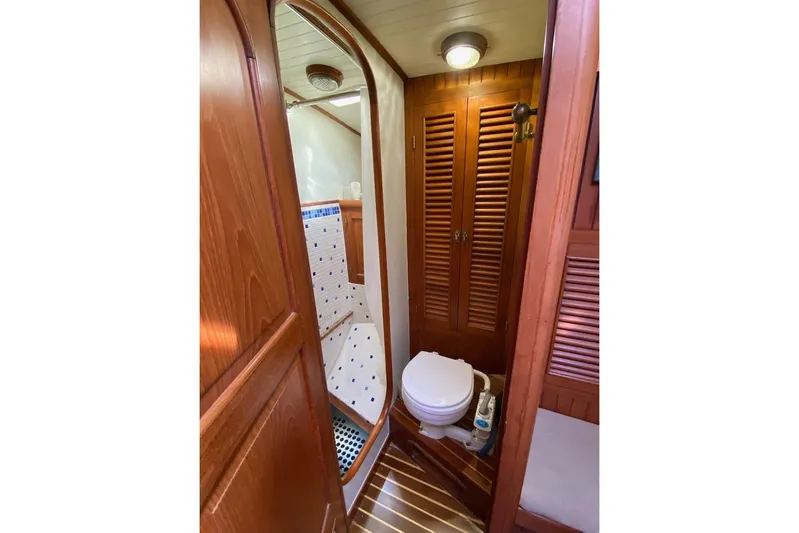 Ganache II Yacht Photos Pics Wood-paneled bathroom in 1985 Liberty 458 yacht with toilet and shower.