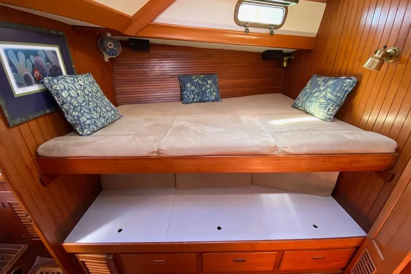 Ganache II Yacht Photos Pics Cozy cabin bed in 1985 Liberty 458 yacht with wooden paneling and decorative pillows.