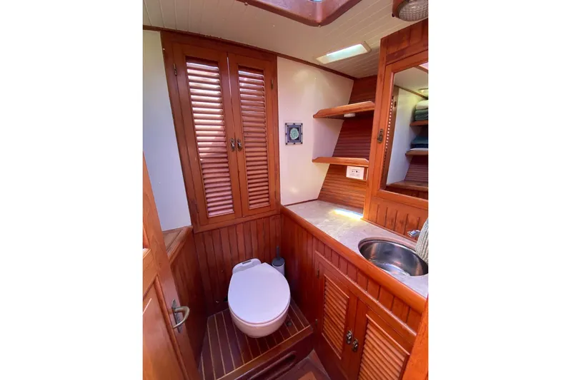 Ganache II Yacht Photos Pics 1985 Liberty 458 yacht bathroom with wooden cabinetry, toilet, and sink.