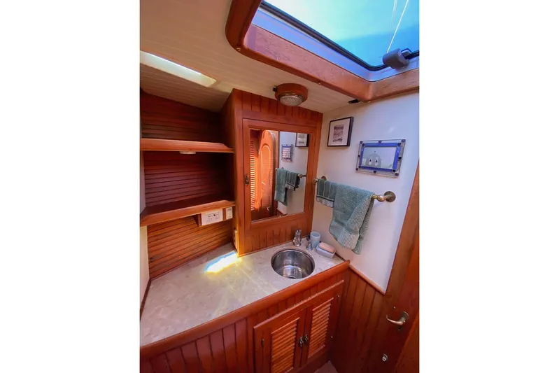 Ganache II Yacht Photos Pics Vintage 1985 Liberty 458 yacht bathroom with wooden cabinetry and skylight.