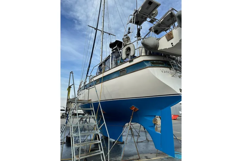 Ganache II Yacht Photos Pics Sailboat Liberty 458, 1985 model, on dry dock with blue hull and scaffolding.