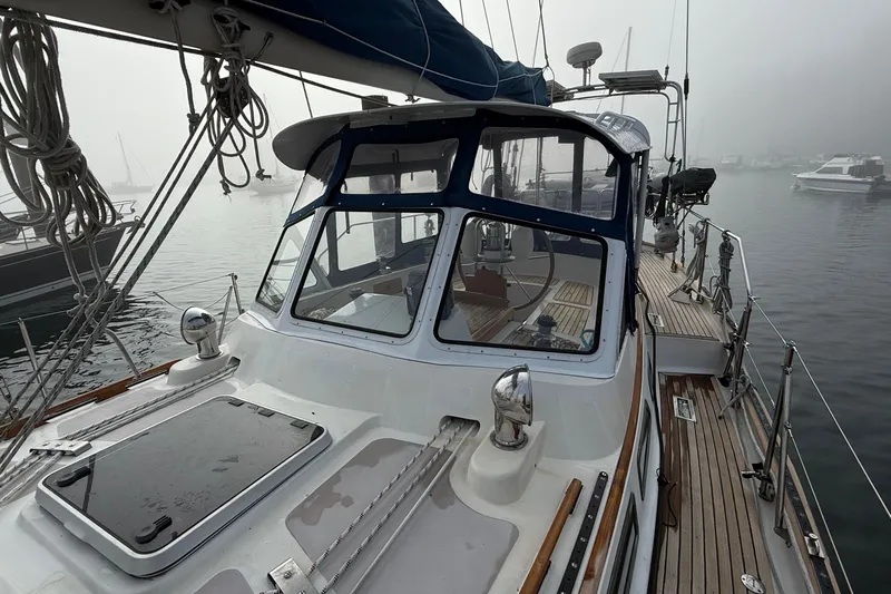Ganache II Yacht Photos Pics 1985 Liberty 458 sailboat on misty water, showcasing deck and cockpit area.