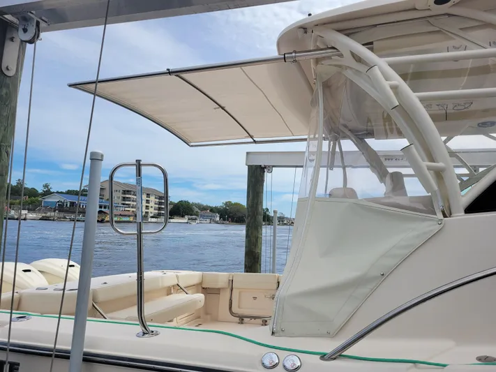  Yacht Photos Pics 2022 Grady-White Express 370 boat docked by the water, featuring a covered seating area.