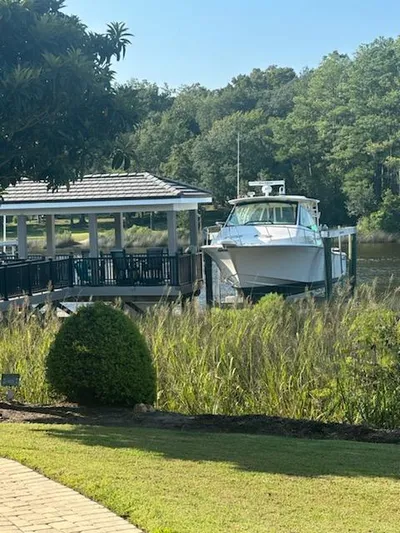  Yacht Photos Pics 2022 Grady-White Express 370 docked near lush greenery and a gazebo.