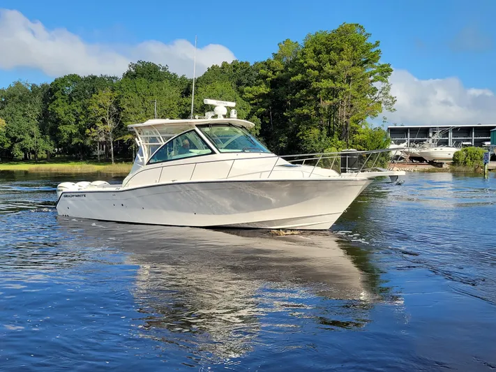  Yacht Photos Pics 2022 Grady-White Express 370 boat cruising on a serene lake with lush greenery.