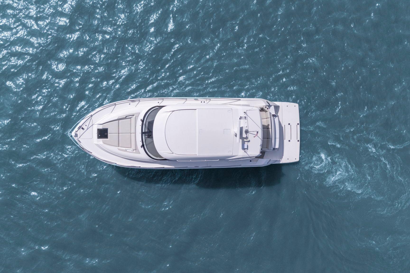 Aerial view of 2023 Tiara Yachts C49 Coupe on blue ocean water.