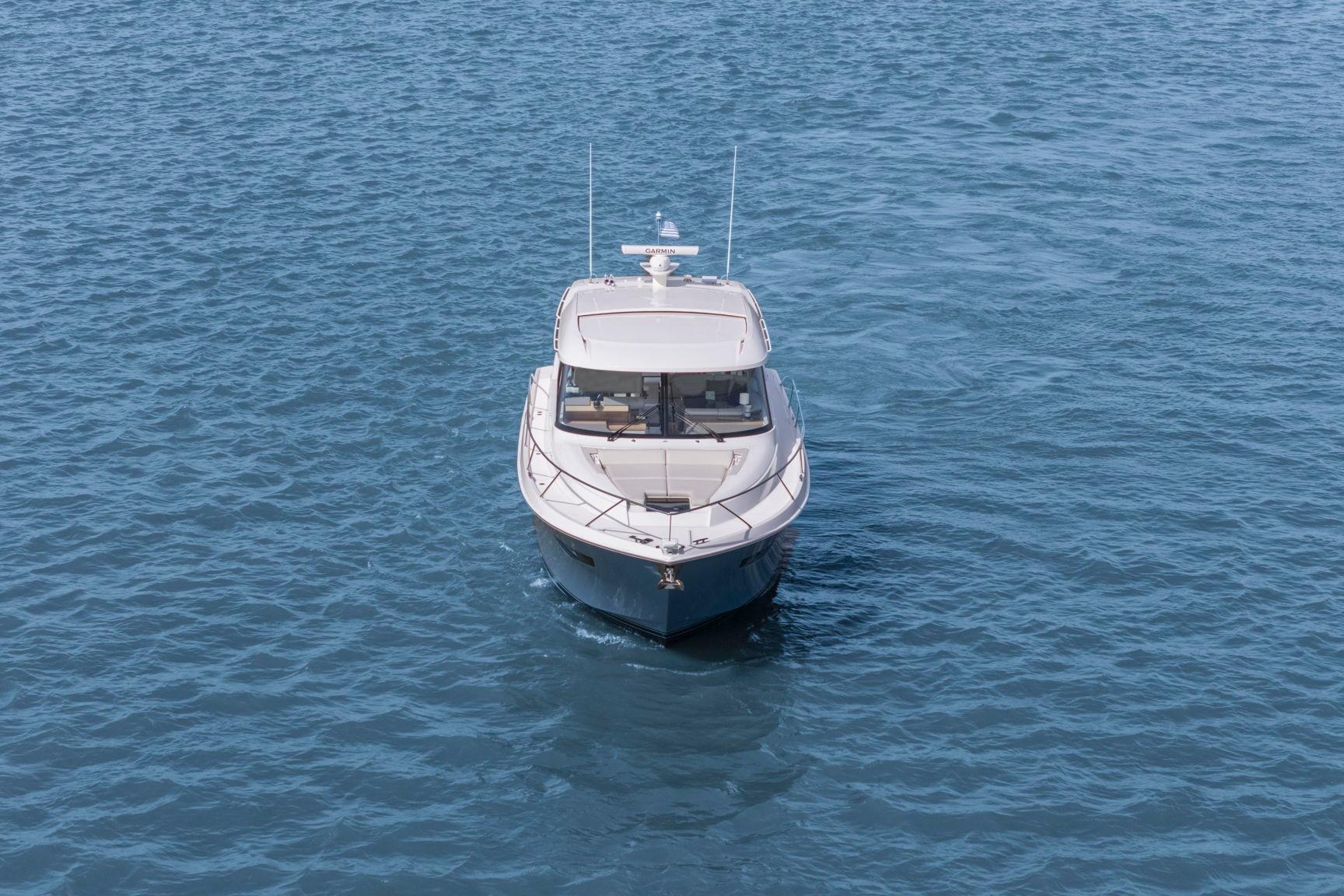 2023 Tiara Yachts C49 Coupe cruising on open water, front view.