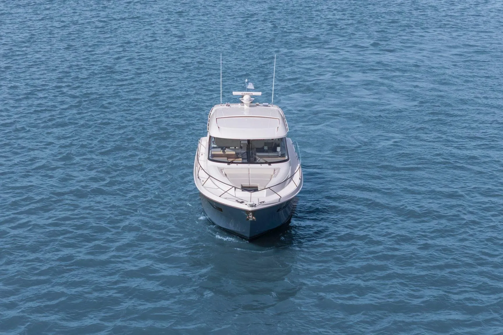 2023 Tiara Yachts C49 Coupe cruising on open water, front view.