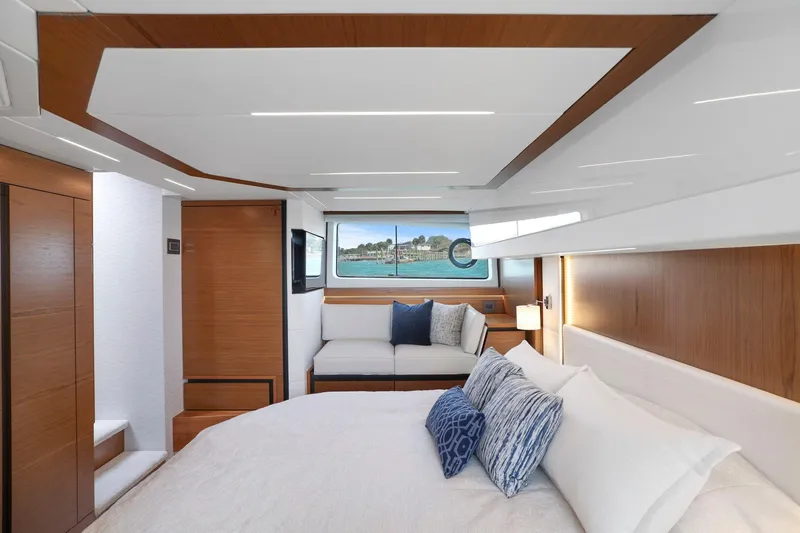 Seeker Yacht Photos Pics Luxurious interior of 2023 Tiara Yachts C49 Coupe with elegant wood finishes and plush bedding.