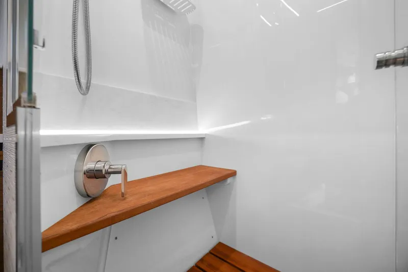 Seeker Yacht Photos Pics 2023 Tiara Yachts C49 Coupe shower with wooden bench and modern fixtures.