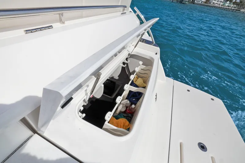 Seeker Yacht Photos Pics 2023 Tiara Yachts C49 Coupe storage compartment open on deck, near blue ocean water.