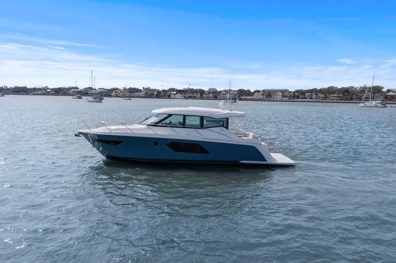Seeker Yacht Photos Pics 2023 Tiara Yachts C49 Coupe cruising on a calm, scenic waterway.