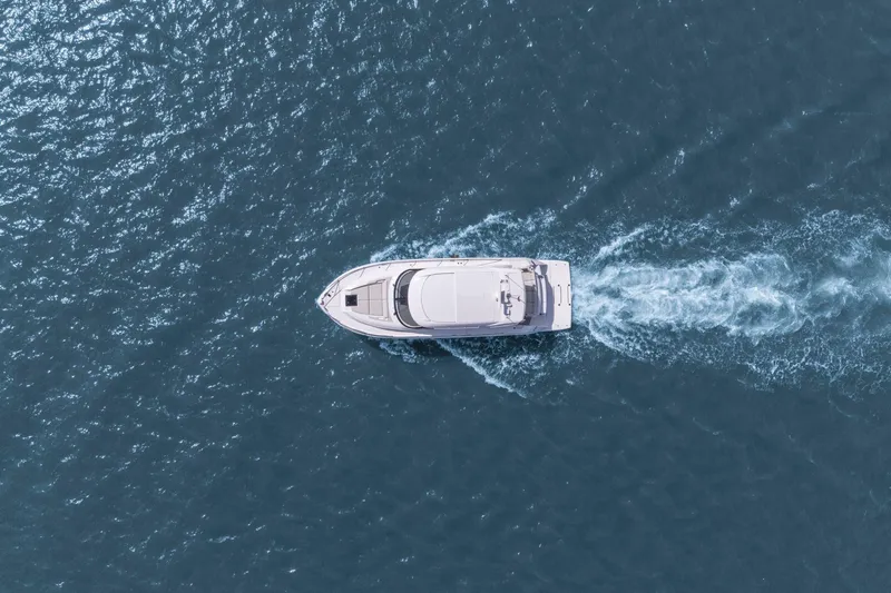Seeker Yacht Photos Pics Aerial view of 2023 Tiara Yachts C49 Coupe cruising on open water.
