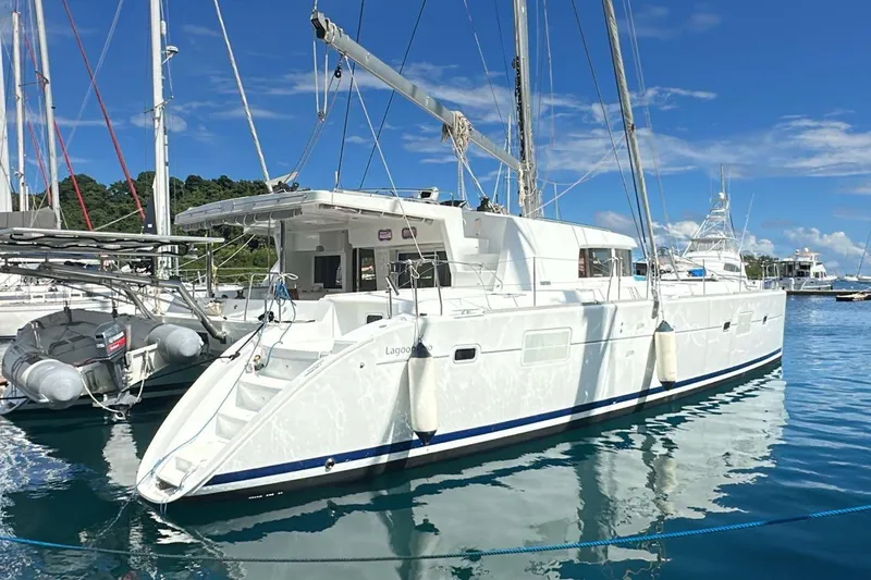  Yacht Photos Pics 2010 Lagoon 500 catamaran docked in a sunny marina, reflecting on calm water.