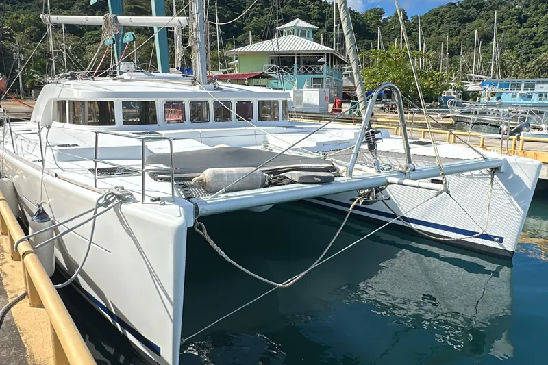  Yacht Photos Pics 2010 Lagoon 500 catamaran docked at a marina, surrounded by lush greenery.
