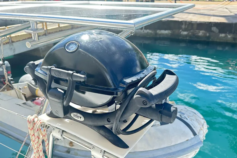  Yacht Photos Pics Portable grill on Lagoon 500 yacht, docked by clear blue water.
