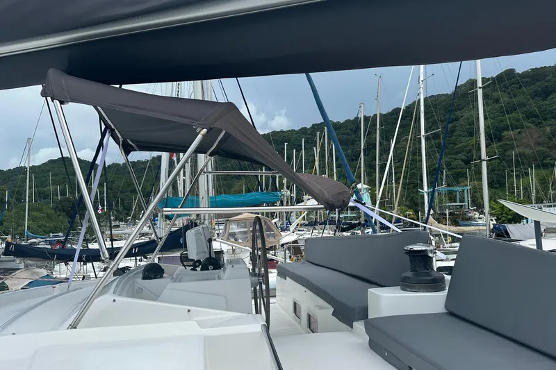  Yacht Photos Pics Lagoon 500 catamaran, 2010 model, docked in a marina with lush green hills in the background.