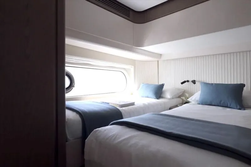  Yacht Photos Pics Luxurious twin cabin in 2025 Azimut 60 Magellano yacht, featuring elegant bedding and porthole view.