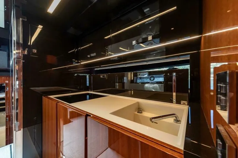 2021 Riva 56 Rivale &ldquo;grey&rdquo; Yacht Photos Pics Luxurious kitchen interior of 2021 Riva 56 yacht with sleek black and wood finishes.