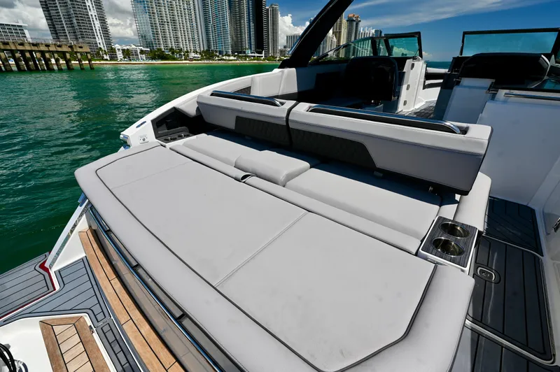  Yacht Photos Pics 2025 Cobalt R33 Outboard boat with luxurious seating, docked near city skyline.