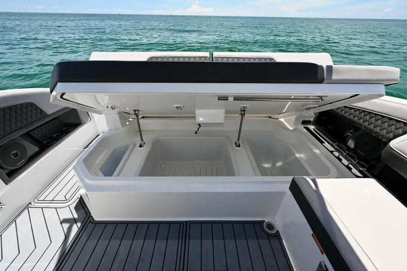  Yacht Photos Pics Open storage compartment on 2025 Cobalt R33 Outboard boat, with ocean view in background.