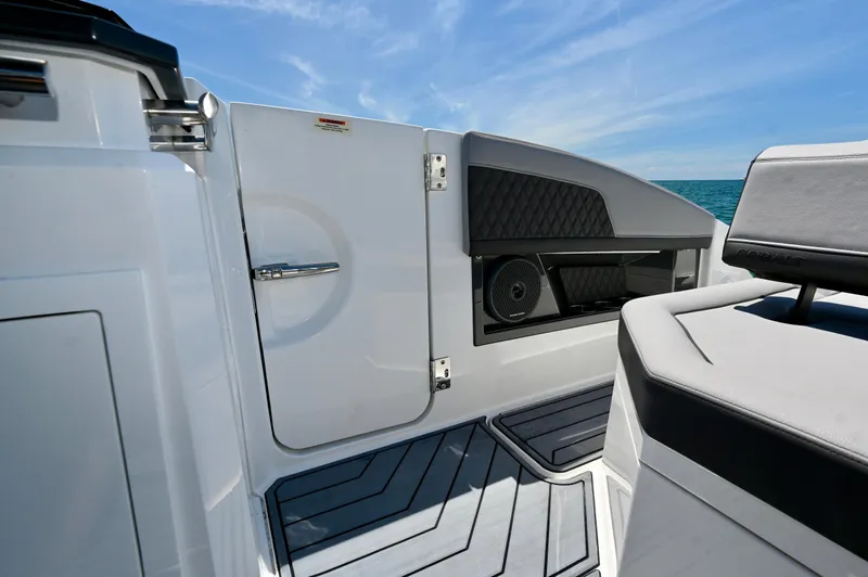  Yacht Photos Pics 2025 Cobalt R33 Outboard boat interior with seating and speaker, ocean view.