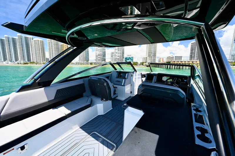  Yacht Photos Pics 2025 Cobalt R33 Outboard boat interior with city skyline and turquoise water backdrop.
