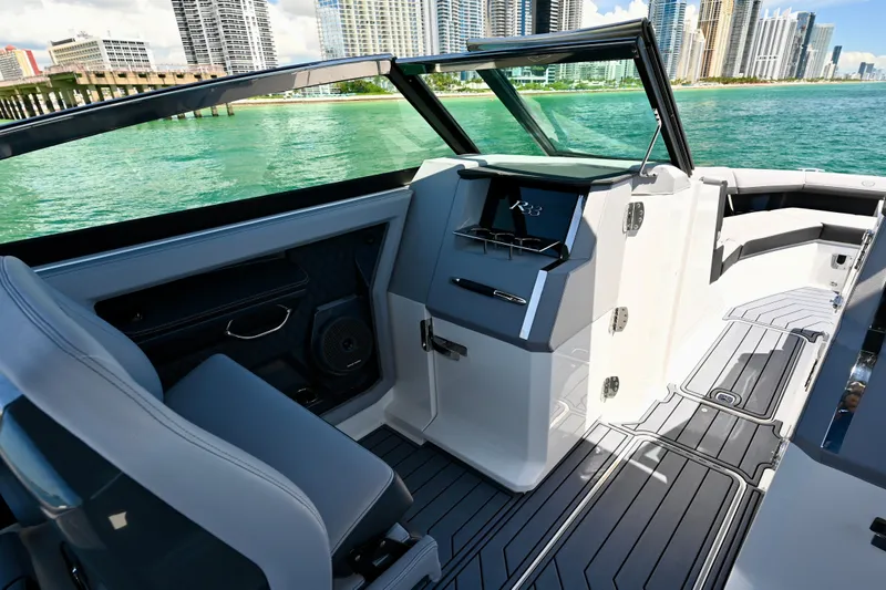  Yacht Photos Pics 2025 Cobalt R33 Outboard boat interior with sleek design, city skyline, and turquoise water.